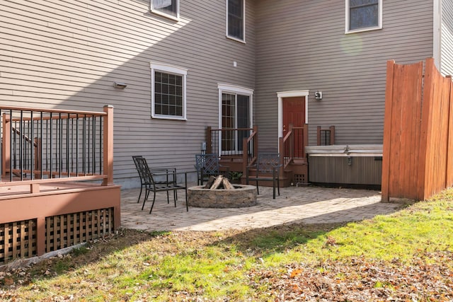 exterior space featuring a hot tub, a fire pit, and a wooden deck