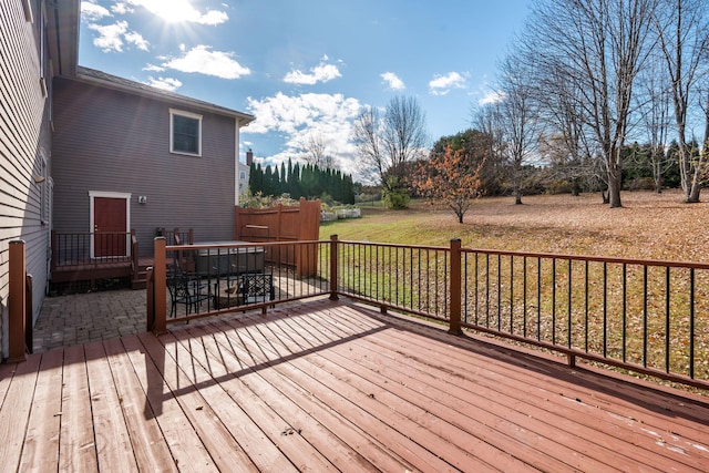 wooden terrace with a hot tub and a yard