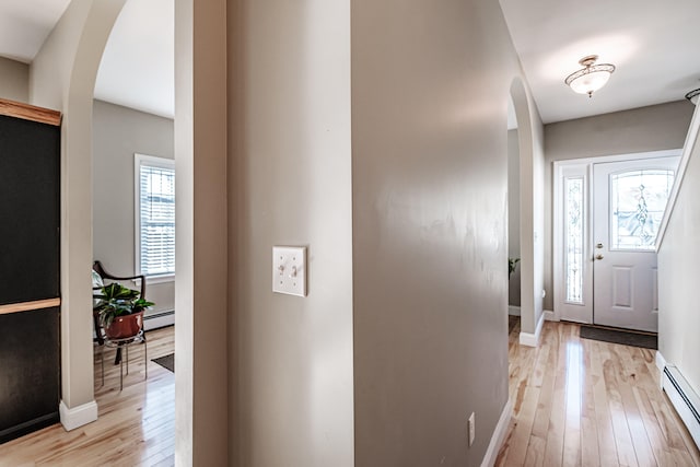 foyer entrance with light wood-type flooring and baseboard heating