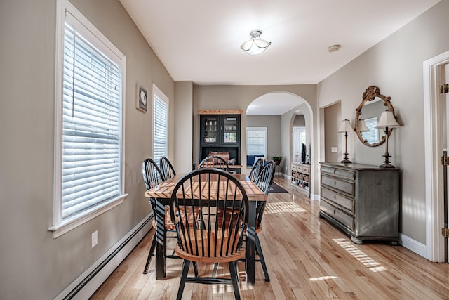 dining space with light hardwood / wood-style flooring and a baseboard radiator