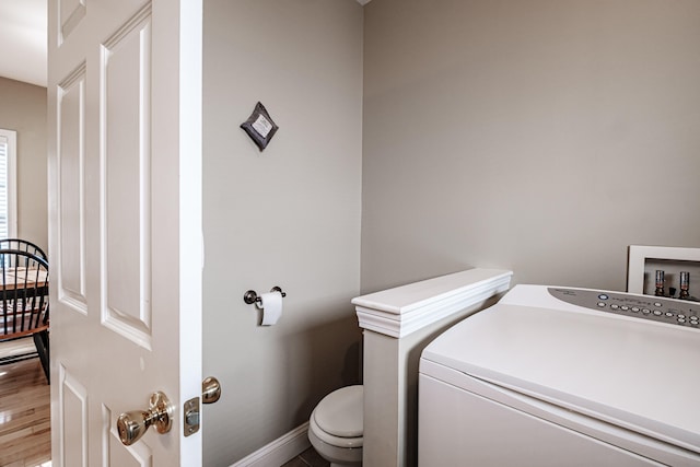 bathroom featuring washer / clothes dryer and toilet