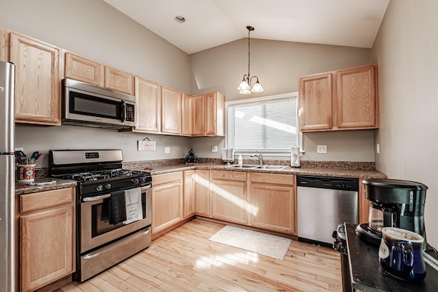 kitchen with appliances with stainless steel finishes, light brown cabinets, a notable chandelier, and sink