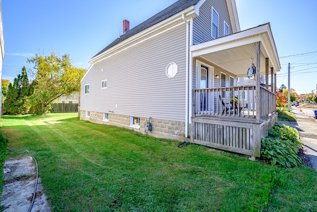 view of property exterior featuring covered porch and a yard