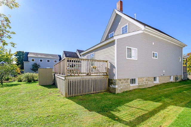 back of property featuring a lawn and a wooden deck