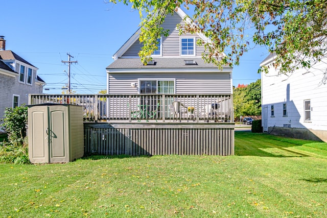 back of property with a yard, a shed, and a wooden deck