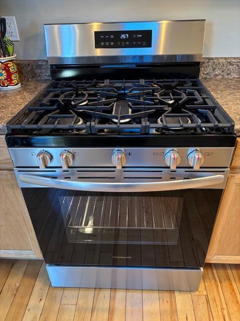 room details with stainless steel gas stove and light brown cabinets