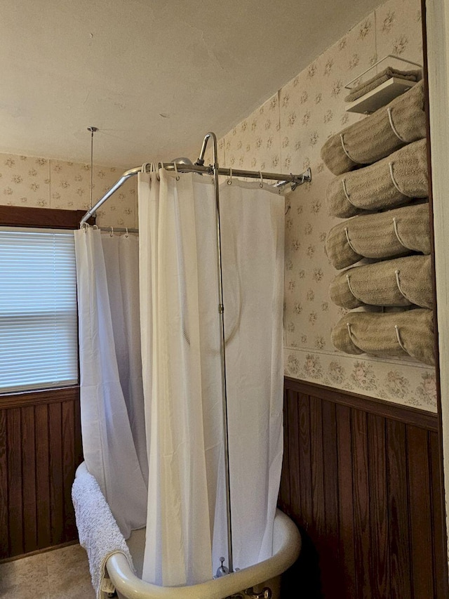 bathroom featuring walk in shower and wood walls