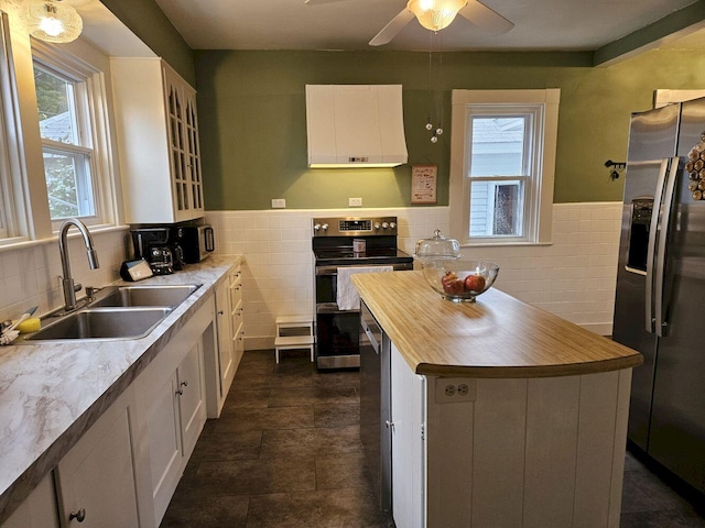 kitchen featuring white cabinets, sink, plenty of natural light, stainless steel appliances, and a center island