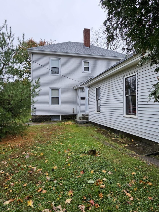 rear view of property featuring a lawn