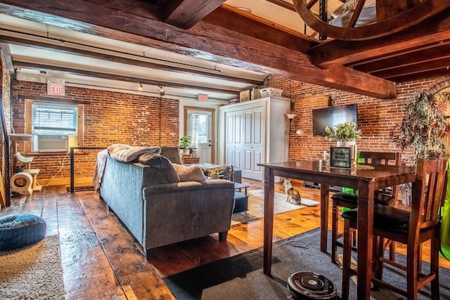 living room featuring cooling unit, dark hardwood / wood-style floors, beamed ceiling, and brick wall