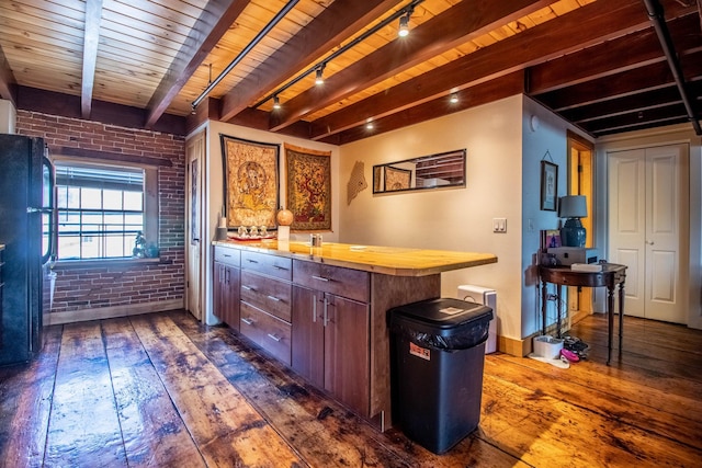 bar with dark wood-type flooring, wooden ceiling, beamed ceiling, and brick wall