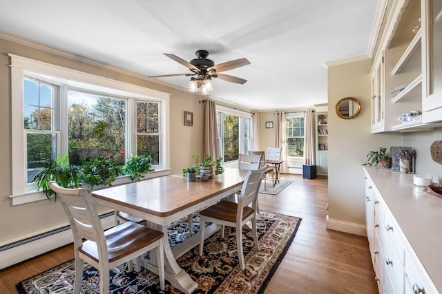 dining room featuring ornamental molding, light hardwood / wood-style floors, a healthy amount of sunlight, and ceiling fan