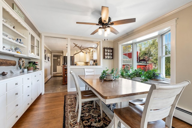 dining area with ornamental molding, hardwood / wood-style flooring, baseboard heating, and ceiling fan