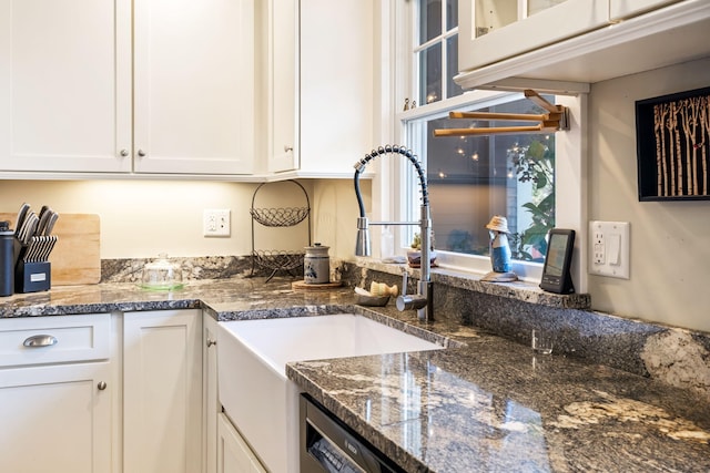 kitchen featuring white cabinetry, dark stone countertops, and sink