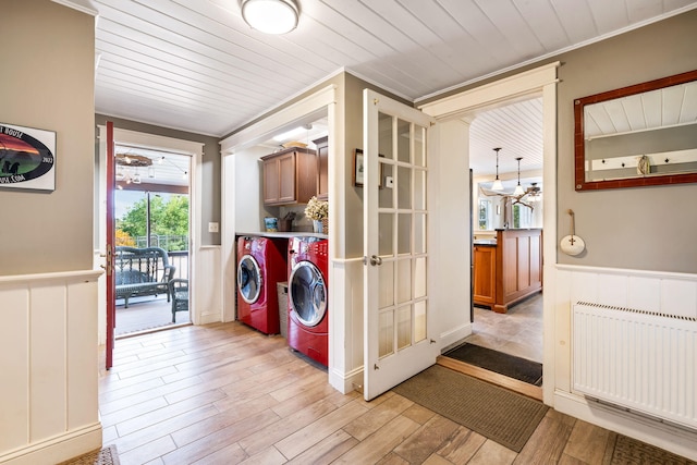 laundry room with light wood-type flooring, washing machine and dryer, cabinets, and radiator