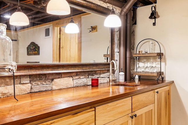 bar with sink, pendant lighting, and wood counters