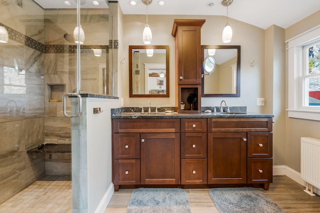 bathroom featuring lofted ceiling, radiator heating unit, hardwood / wood-style floors, walk in shower, and vanity