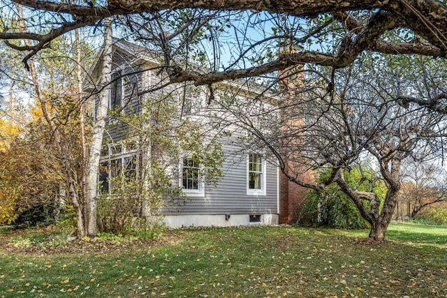 view of side of home with a yard