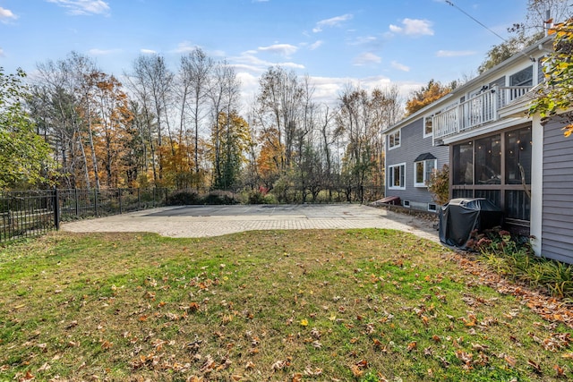 view of yard with a patio, a sunroom, and a balcony