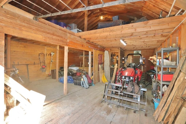 miscellaneous room featuring wood walls, hardwood / wood-style flooring, and vaulted ceiling