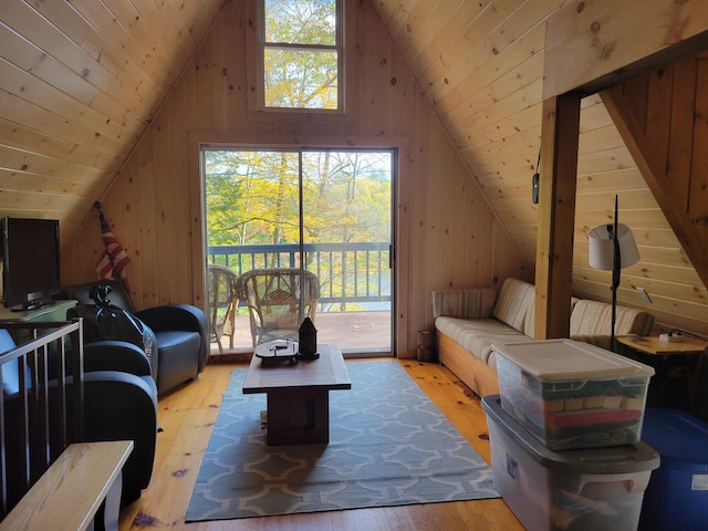 living room with wooden walls, vaulted ceiling, wood ceiling, and light wood-type flooring