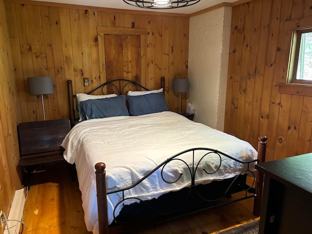 bedroom with wood-type flooring and wood walls