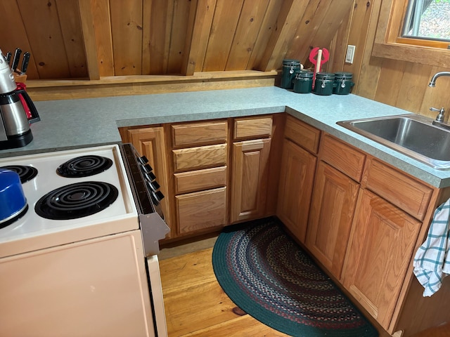 kitchen with white range oven, sink, and kitchen peninsula