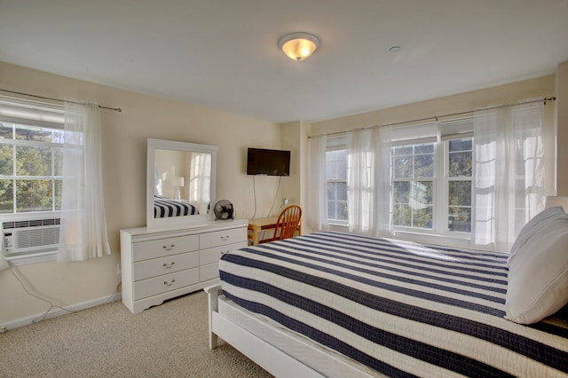 bedroom with cooling unit and light colored carpet