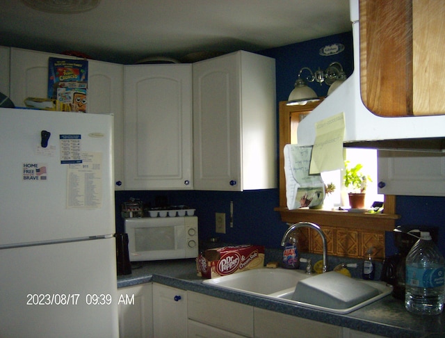 kitchen featuring white cabinets, sink, and white appliances