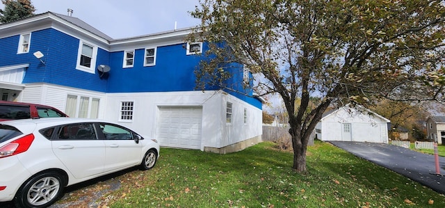 view of side of home with a garage and a lawn