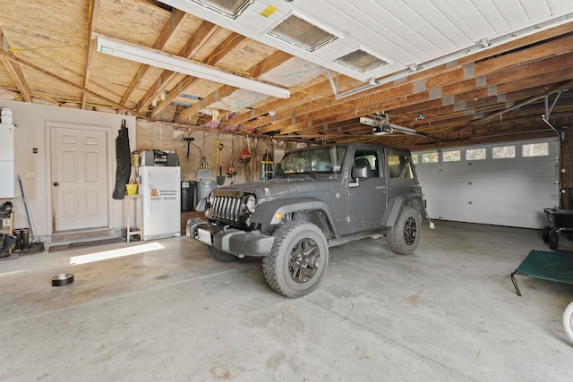 garage featuring white fridge and a garage door opener