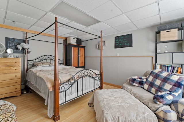 bedroom featuring light hardwood / wood-style floors and a drop ceiling