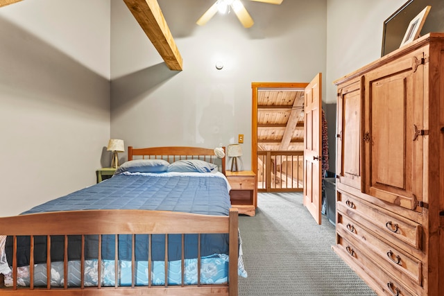 carpeted bedroom featuring ceiling fan and beamed ceiling