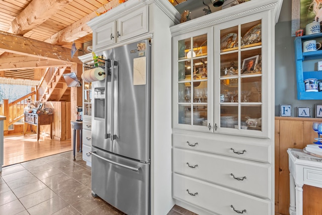 kitchen with white cabinetry, high end fridge, wood ceiling, wood walls, and beamed ceiling