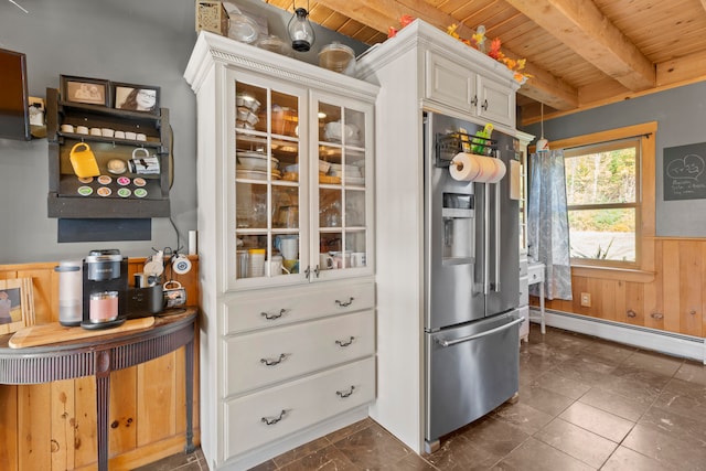 kitchen with white cabinetry, high end fridge, wooden walls, baseboard heating, and beam ceiling