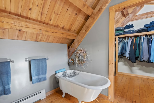 bathroom featuring baseboard heating, hardwood / wood-style flooring, a bath, beam ceiling, and wooden ceiling