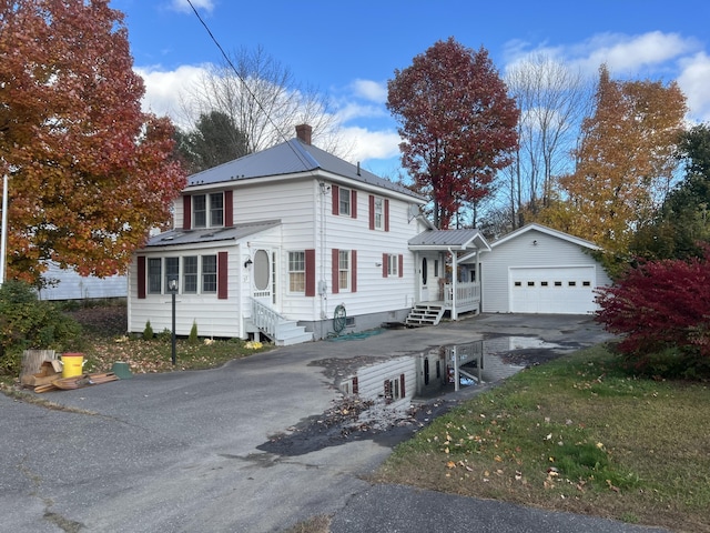 37 Spruce St, East Millinocket, ME 04430 - view of front of house featuring driveway, a chimney, a metal roof, and a garage