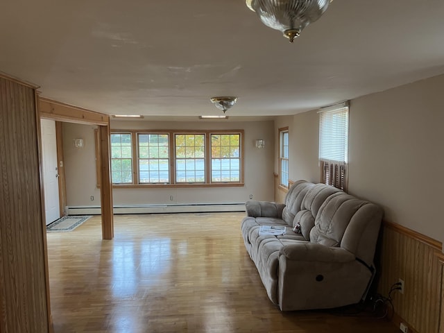 37 Spruce St, East Millinocket, ME 04430 - living area with light wood-type flooring, baseboard heating, and a wainscoted wall