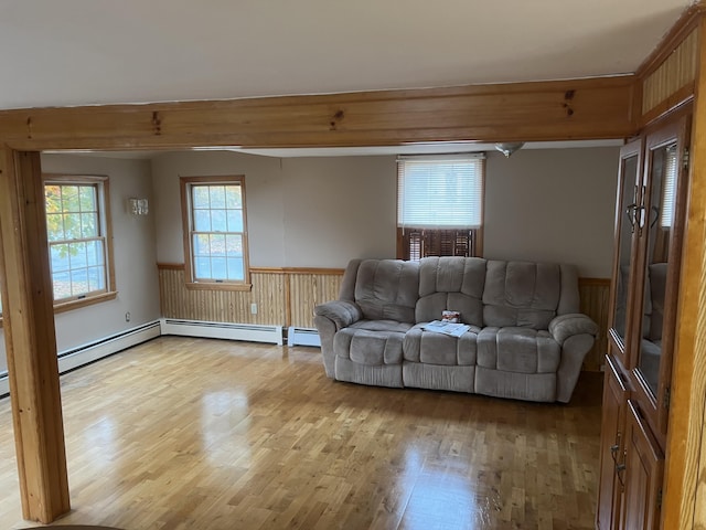 37 Spruce St, East Millinocket, ME 04430 - living room featuring light wood-style flooring, a wainscoted wall, and a baseboard heating unit
