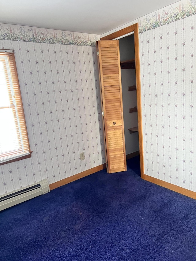 37 Spruce St, East Millinocket, ME 04430 - unfurnished bedroom with dark carpet, multiple windows, a baseboard heating unit, wallpapered walls, and a closet