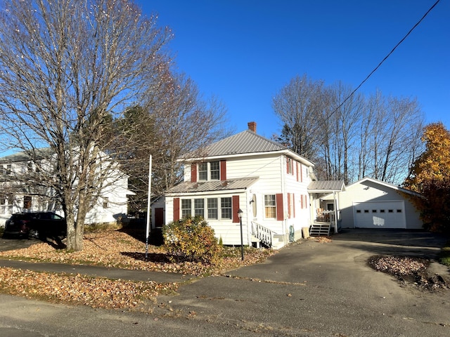 37 Spruce St, East Millinocket, ME 04430 - view of front of house with a garage, a chimney, a metal roof, and asphalt driveway