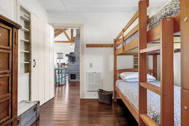 bedroom with heating unit and dark hardwood / wood-style floors