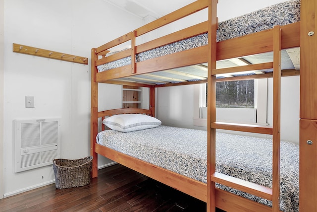 bedroom with heating unit and dark wood-type flooring