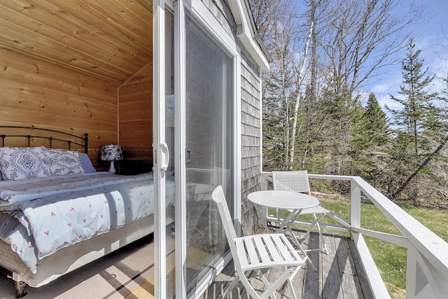 bedroom featuring lofted ceiling and wooden walls