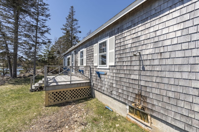 view of side of home featuring a yard and a wooden deck