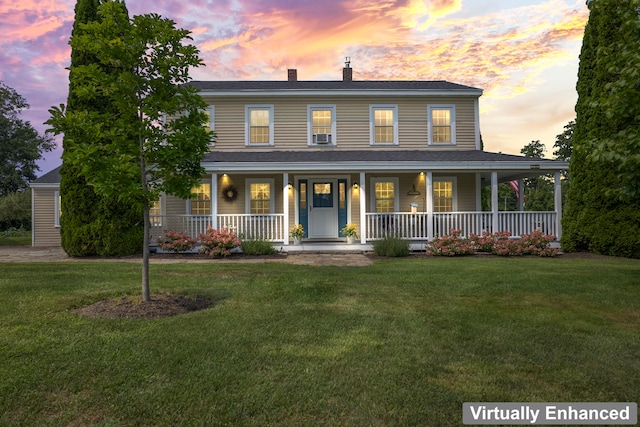 view of front of home with a porch and a yard