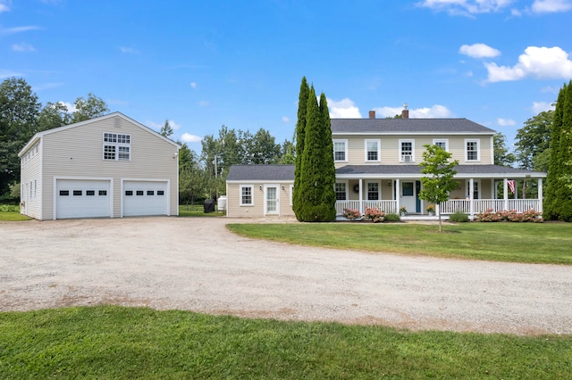 view of front of property with a front yard, an outdoor structure, a garage, and covered porch