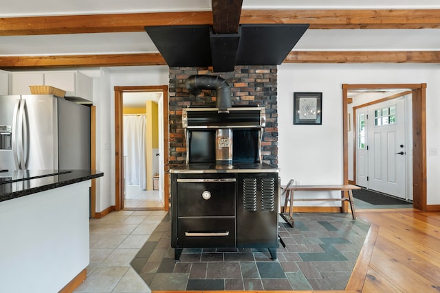 kitchen featuring stainless steel refrigerator with ice dispenser, beam ceiling, and tile patterned floors