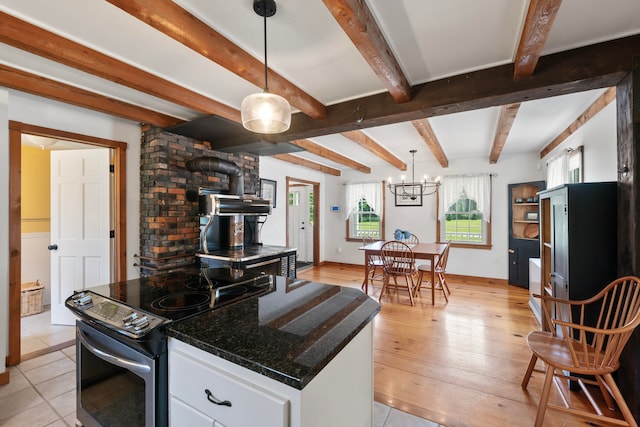 kitchen featuring white cabinets, a wood stove, light hardwood / wood-style flooring, decorative light fixtures, and black range with electric cooktop