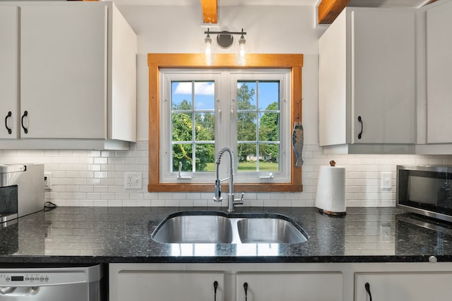 kitchen featuring white cabinets, stainless steel appliances, backsplash, and sink